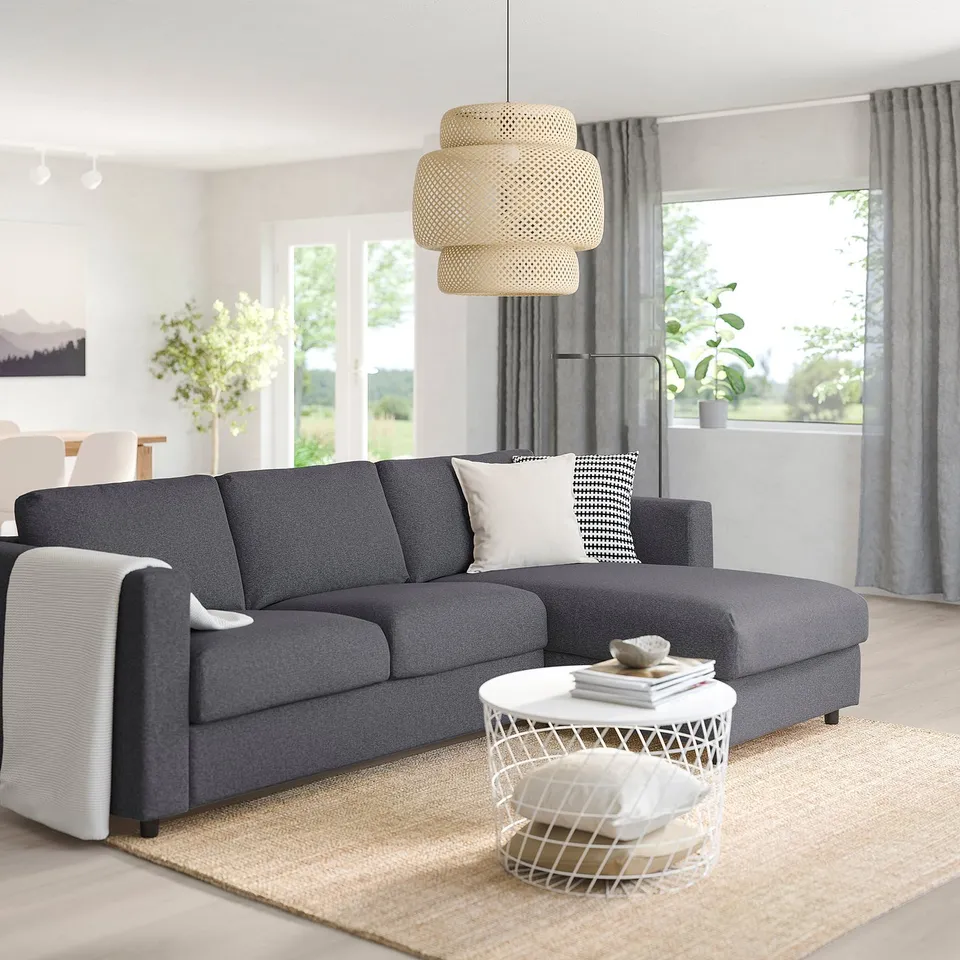 Grey l-shaped VIMLE sectional sofa. Modern, minimalist design. Large, contrasting white coffee table. Tidy, light-filled living room.