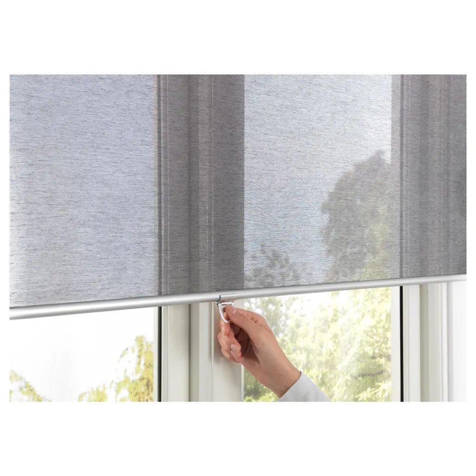 Hand adjusting SKOGSKLÖVER roller blind, cordless, softly closing.