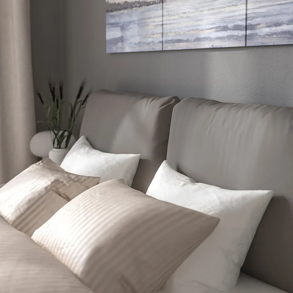 Modern bed with cushioned headboard, easy-clean cover, comfy pillows.