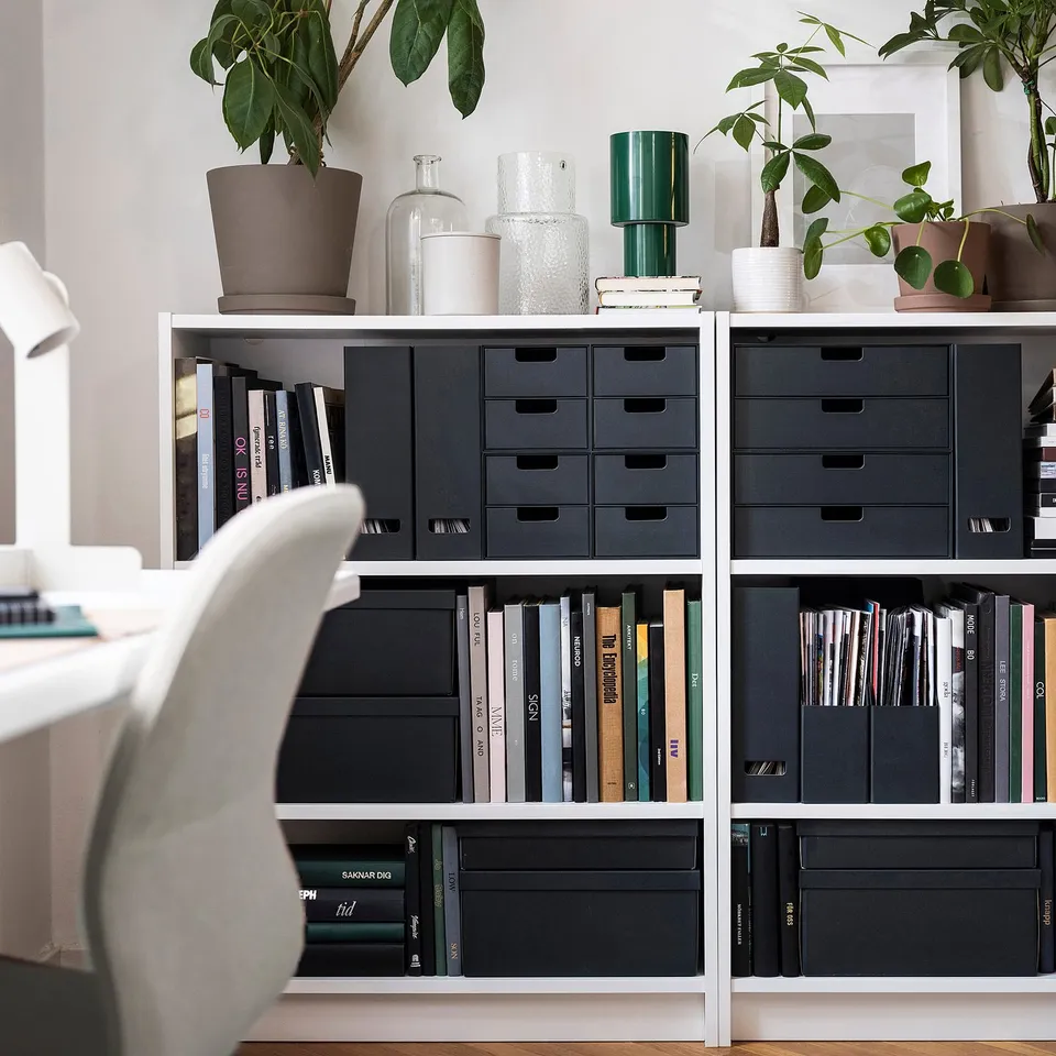 Modern office with bookshelf, FJÄDERHARV drawers, plants, chair.