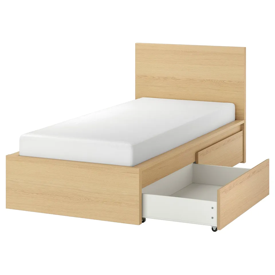A light wooden MALM bed with a white headboard and open drawer for storage. Clean, simple design with oak finish.