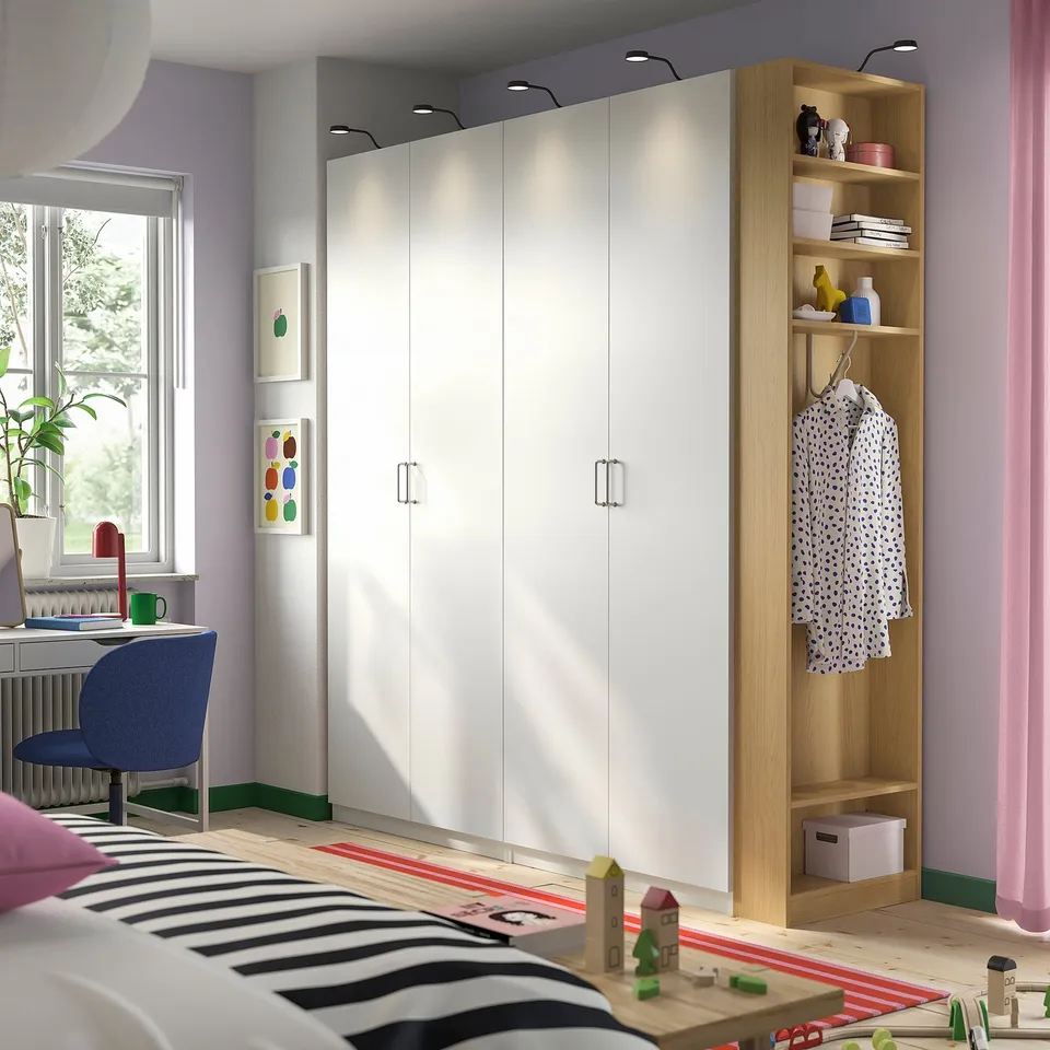 Modern kids room with PAX wardrobe, open unit, desk, and bed with striped blanket.