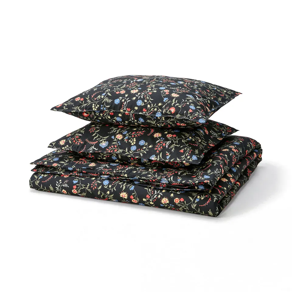 Black duvet set with floral pattern, folded neatly. Made of 100% cotton. Includes cover and pillowcases.