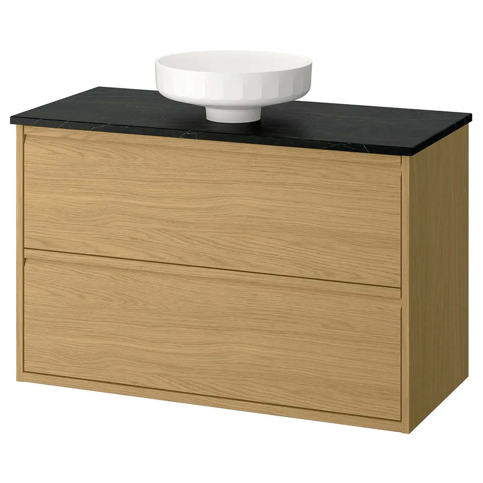 Modern oak bathroom cabinet with black countertop and round white bowl sink, minimalist design with integrated handles.