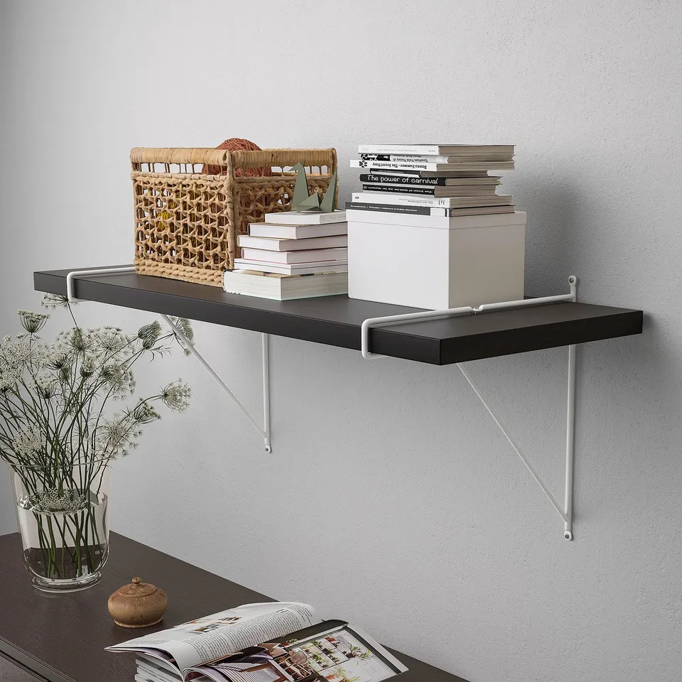 Wall-mounted shelf with books, magazines, and a basket, supported by metal brackets.
