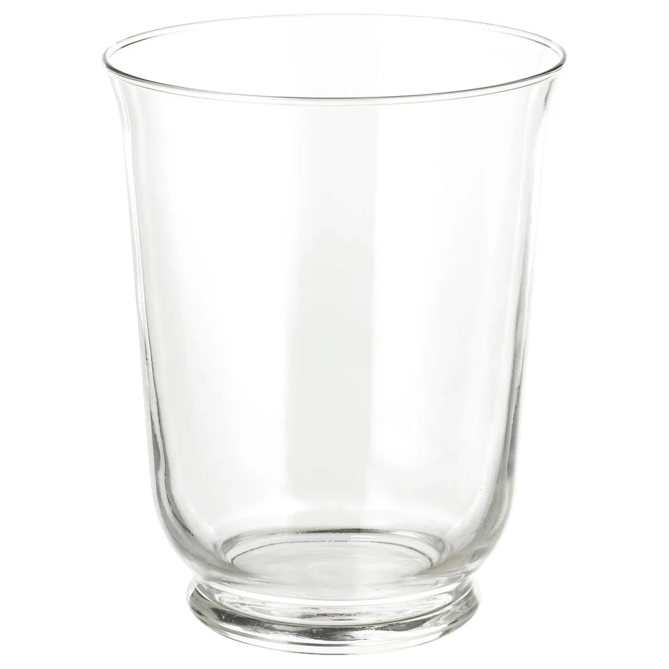 A clear glass vessel, named POMP. Its transparent, cylindrical with a wide mouth, and a circular base. Used as both a vase and lantern.