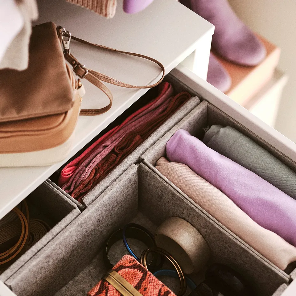 Organised drawer with felt boxes in white, holding scarves and accessories.