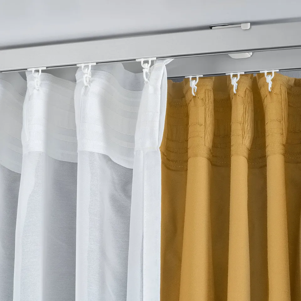 Ceiling-mounted curtain brackets holding dual-layer curtains. The brackets support both sheer and heavy curtains, allowing light control and privacy.