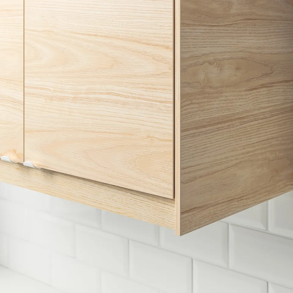 Light wood cabinet panel, part of kitchen series, featuring easy-clean surface. Hangs above white brick backsplash, suits modern kitchens.
