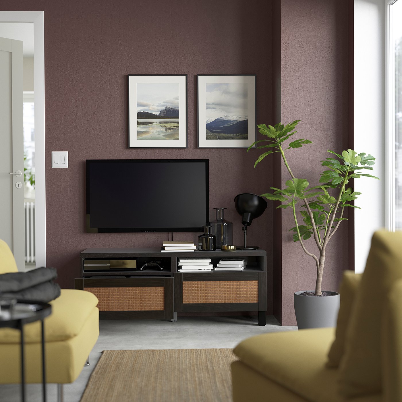 Living room with purple walls, yellow couch, flat screen tv on stand, two framed landscape photos, plant, shelves with books and decor, black lamp.