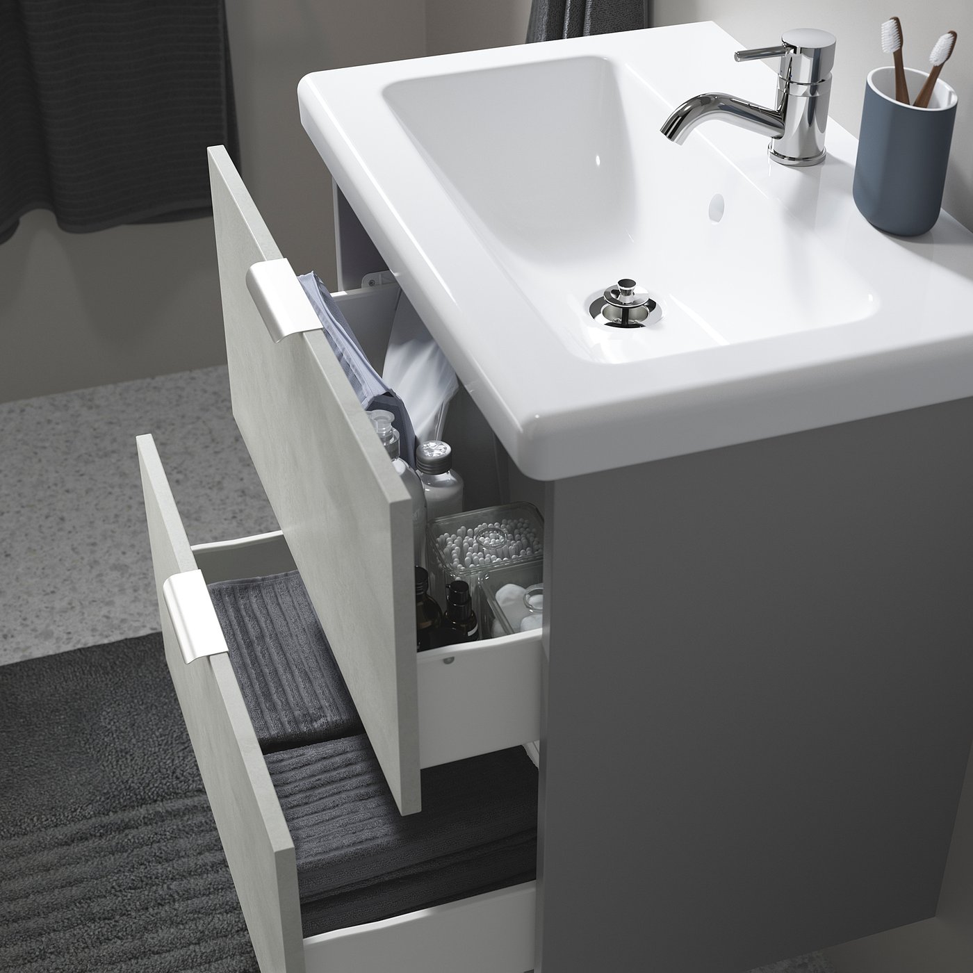 White modern bathroom sink with a drawer open, revealing storage for toiletries.