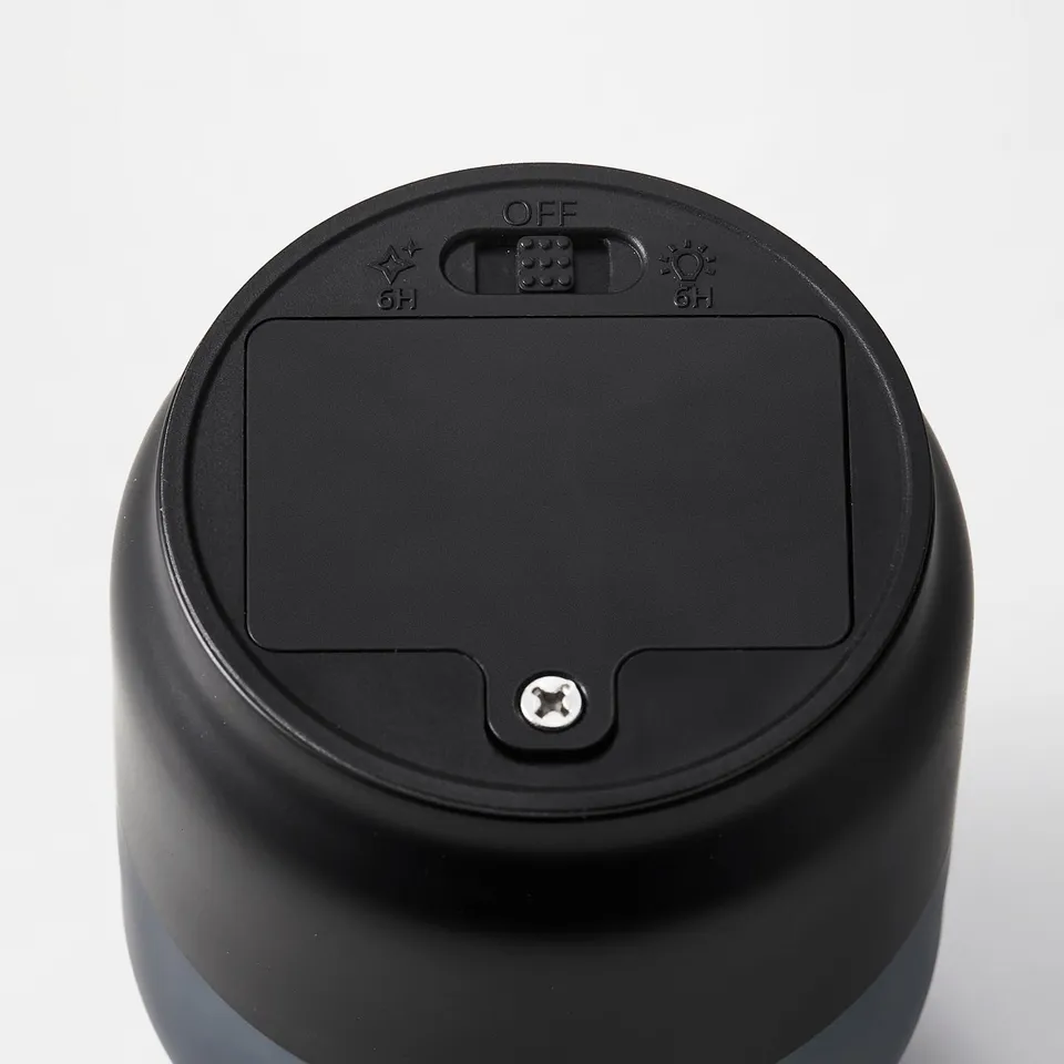 Black cylindrical battery-operated led candle with a frosted glass cover, featuring an on/off switch and timer settings.
