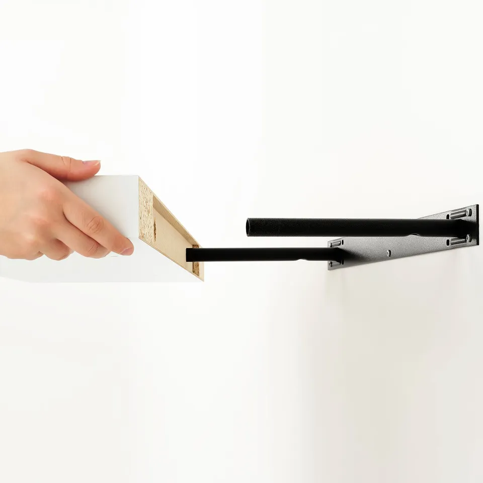 Hand holding a white LACK shelf against a wall, showing its hidden suspension brackets for discreet display.