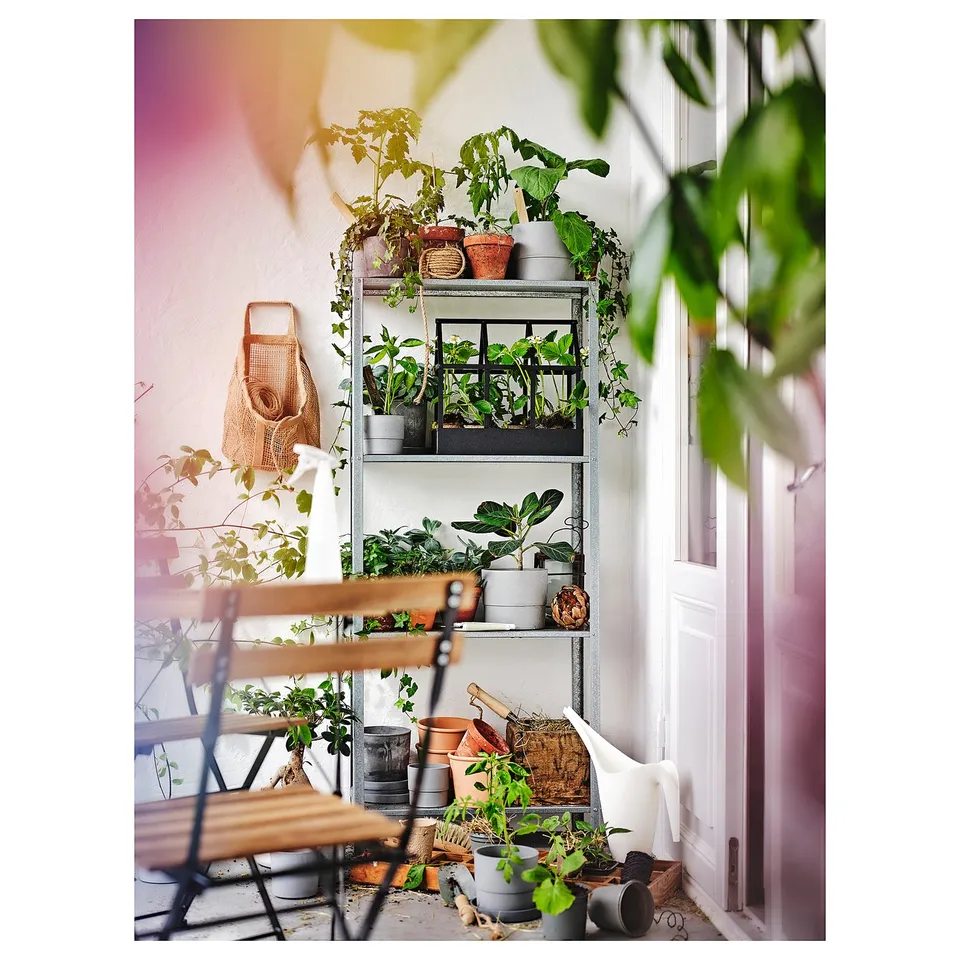 Balcony setup: HYLLIS shelving with potted plants and chair.