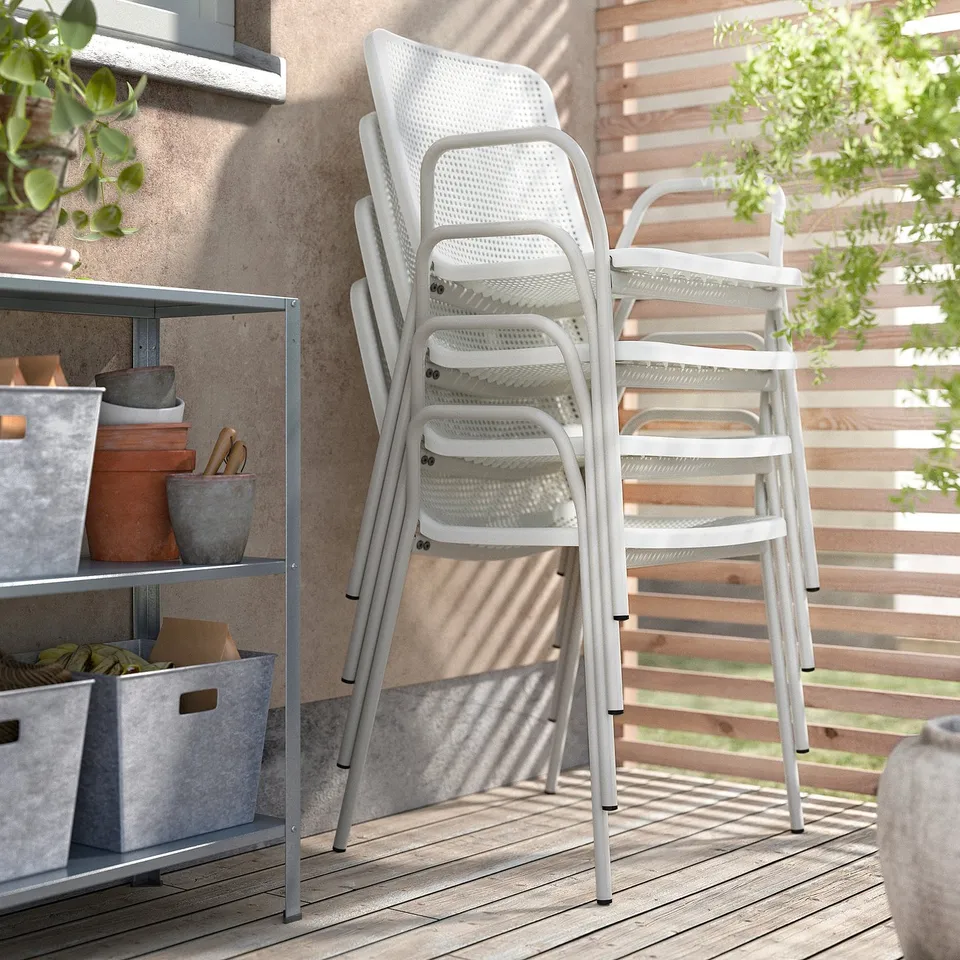 TORPARÖ white outdoor chairs, stackable, made of metal and plastic, on wooden deck.