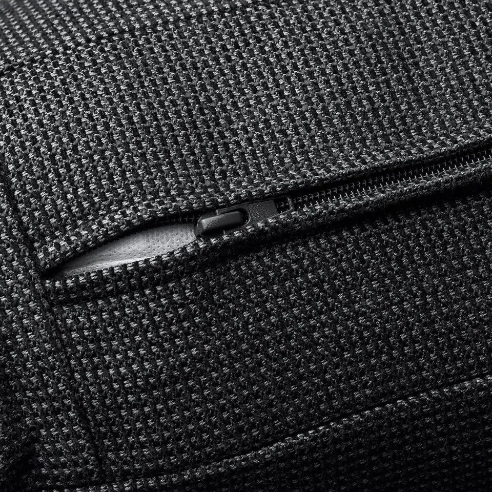 Close-up of high-quality zip on textured, dark fabric, showcasing durability and craftsmanship.