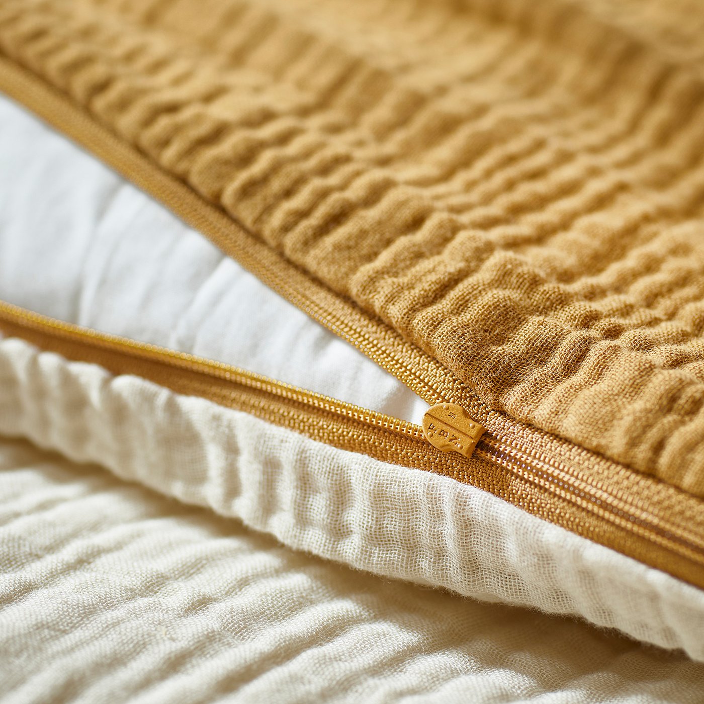 Close-up of a mustard-colored GULDVÄVARE duvet cover zip.