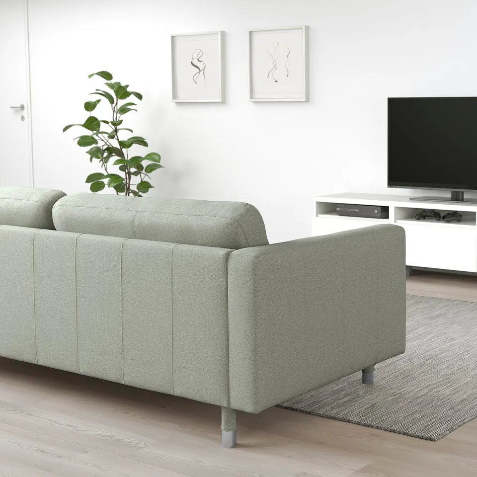 Modern living room with green LANDSKRONA sofa, flatscreen tv, plant, and art.