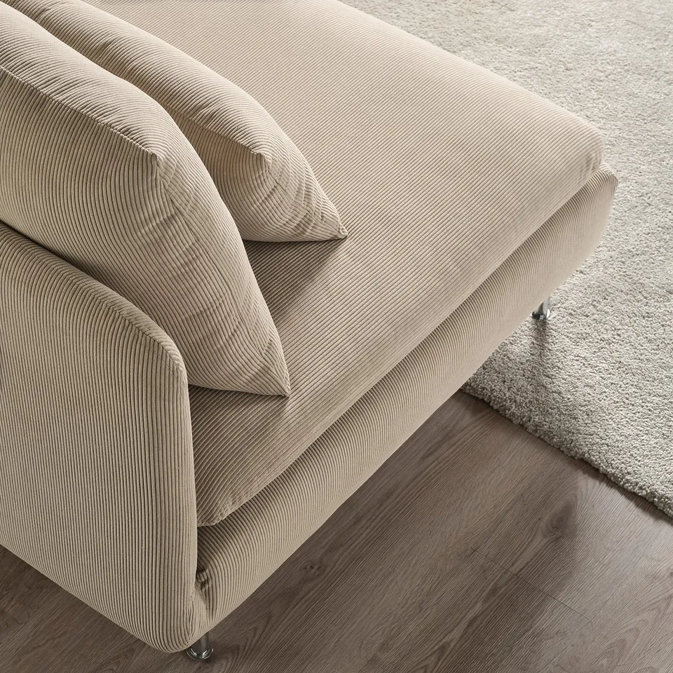 A beige, striped upholstered sofa on wooden floors next to a light rug.
