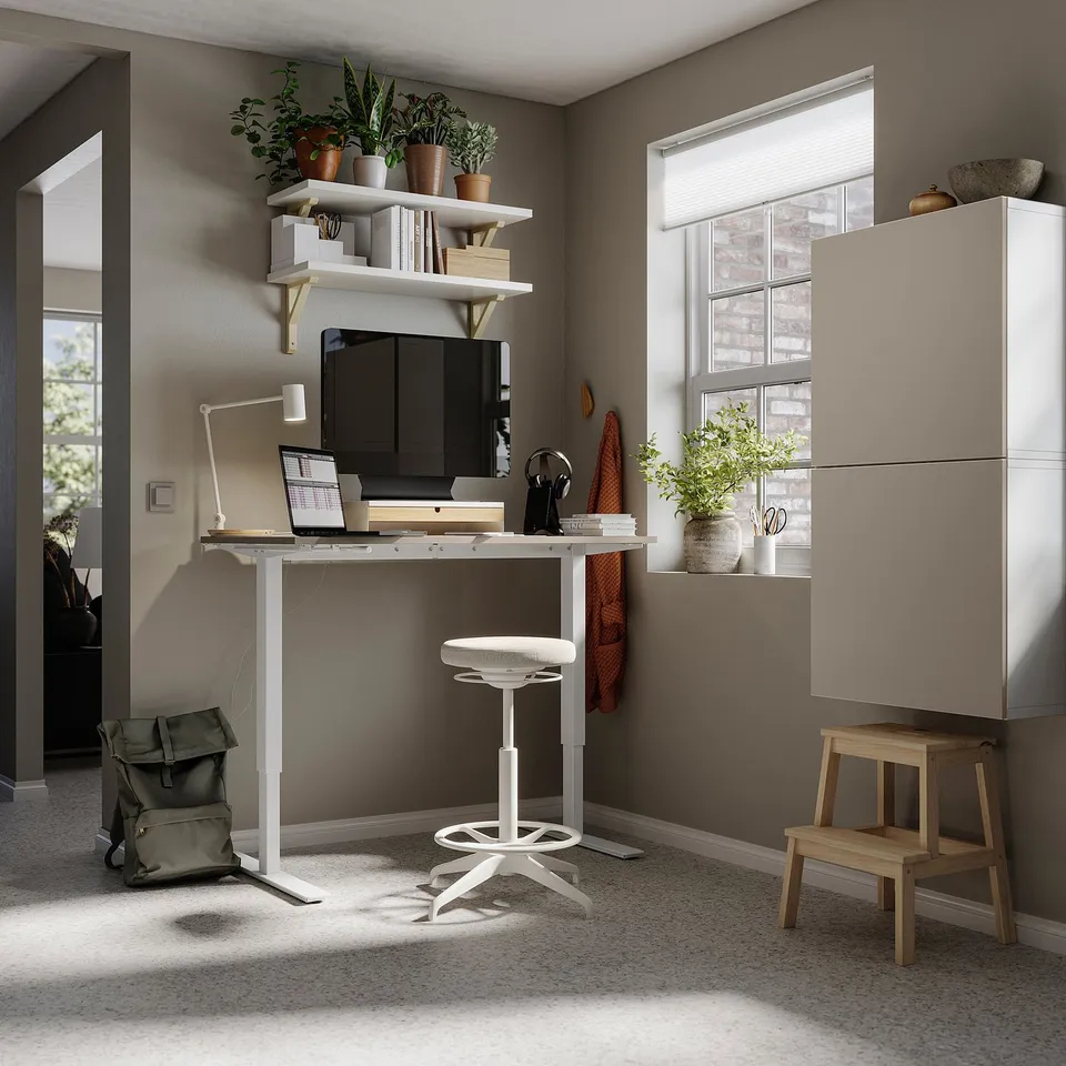 Modern workspace with BESTÅ desk, adjustable chair, shelves with plants, high cabinet, stool.