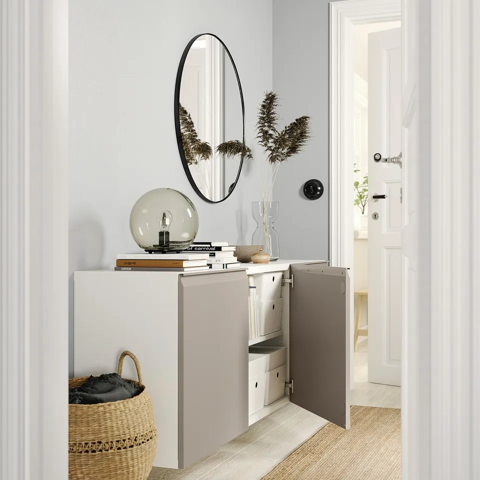 BESTÅ wall cabinet with mirror, bulb, vase, and basket.