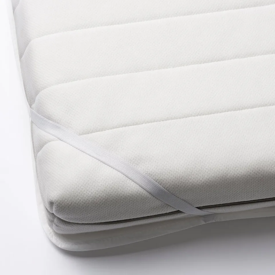 White mattress protector with elastic ribbons for a snug fit.
