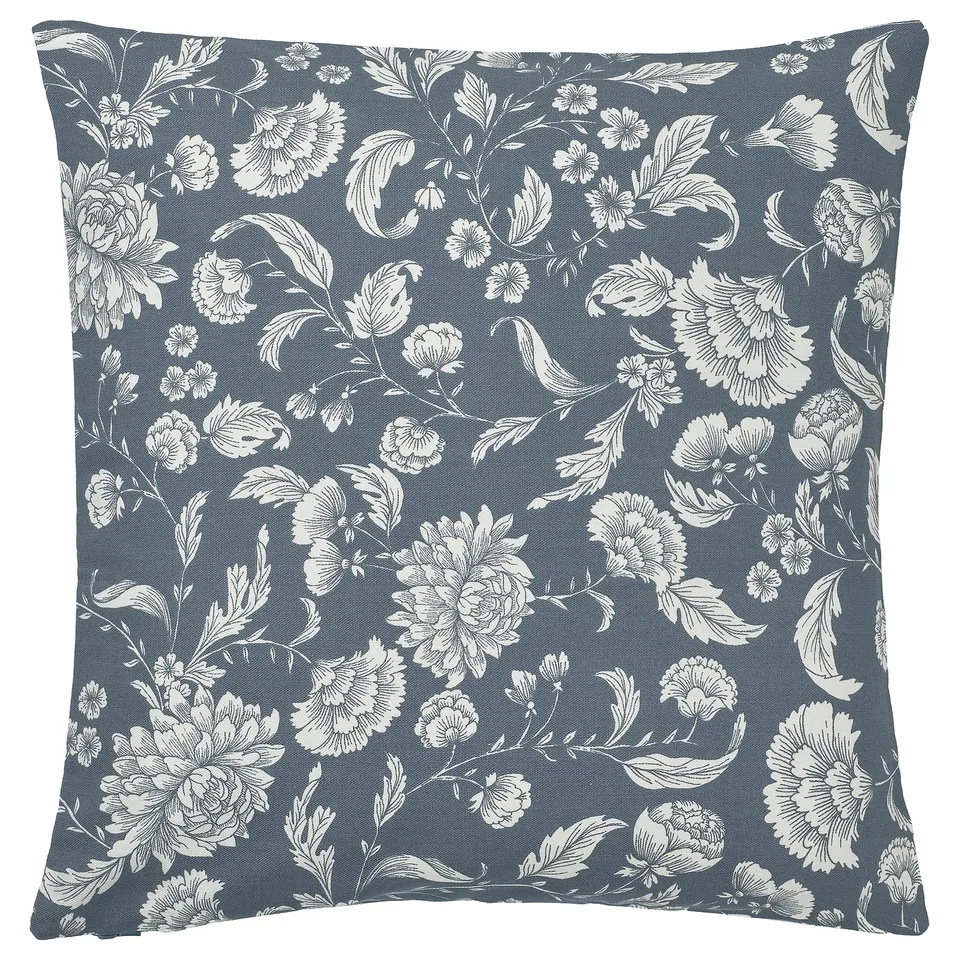 Square blue pillow with white floral pattern.