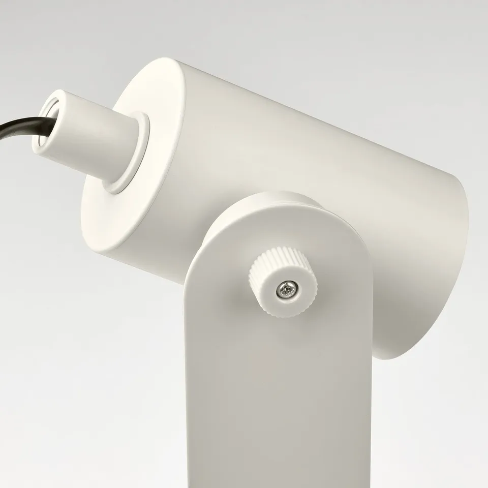 The FLOTTILJ lamps sleek white design, featuring adjustable, robust plastic components and a smooth finish, signifies high-quality craftsmanship.