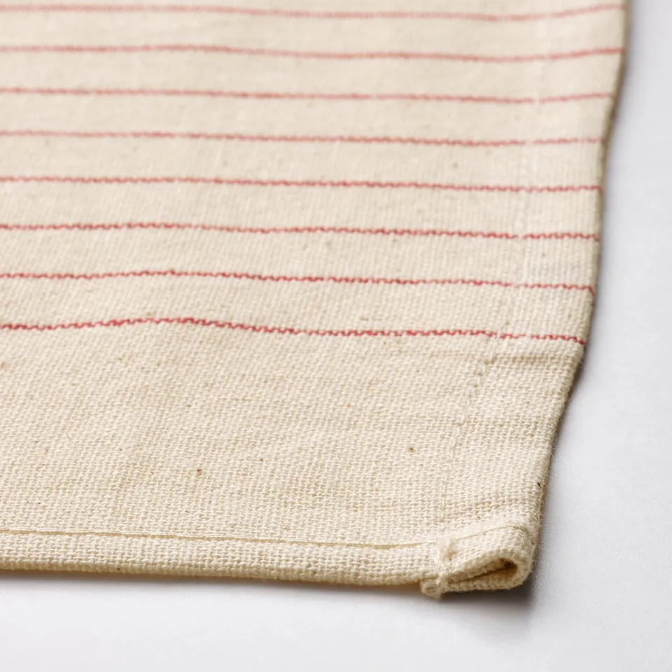 Textured, cream-colored cloth with red horizontal stripes, folded neatly.