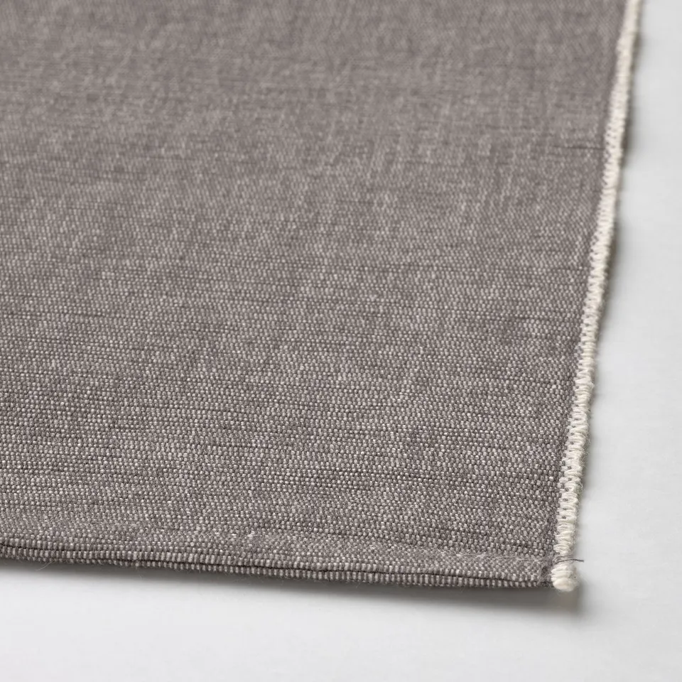 A close-up shot of a neatly stitched grey table runner with fine texture and clean edges.