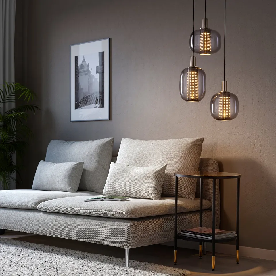 Modern living room with grey sofa, cushions, and pendant lamps. HÖGVIND lamps provide soft, directed lighting with elegant touch.