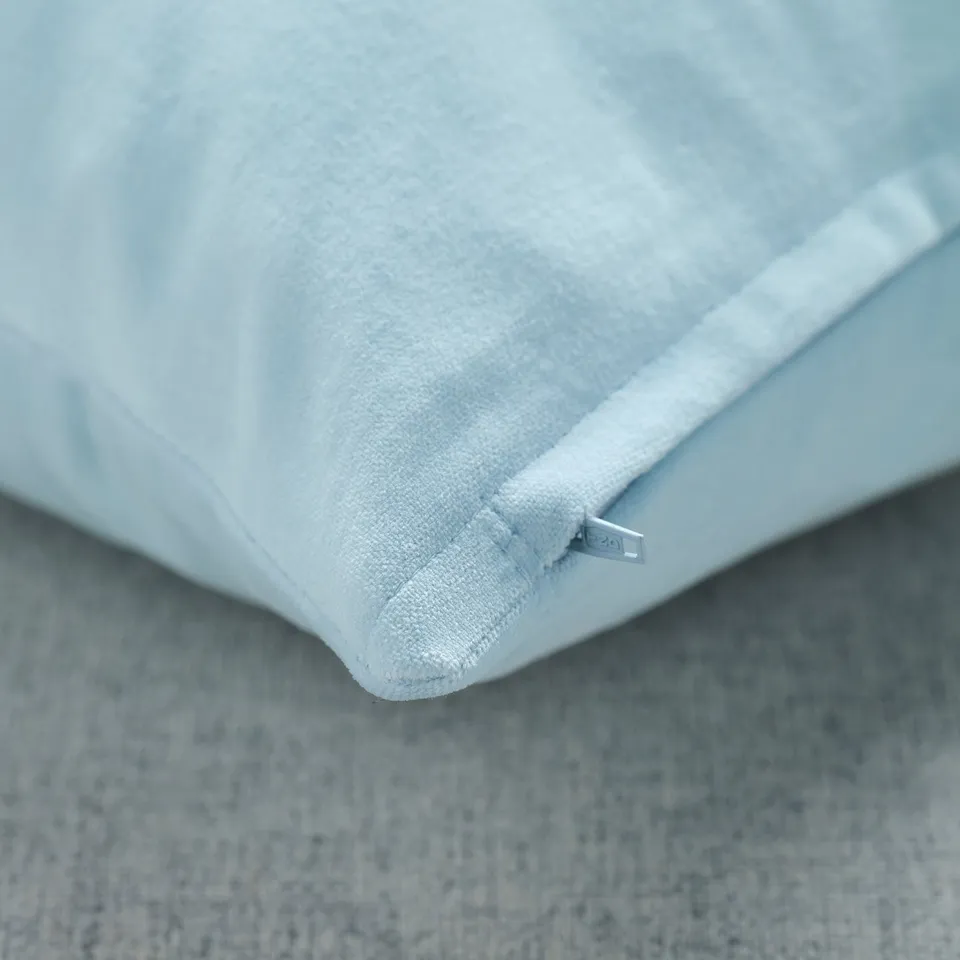 A close-up of a plush, light blue cotton velvet cushion cover showcasing its soft texture and subtle sheen.