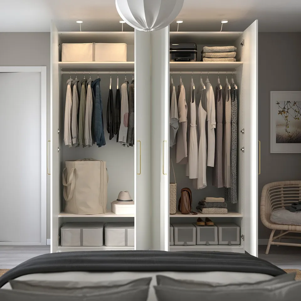Modern open wardrobe with clothes, bags, hats, and storage boxes on shelves; integrated lighting.