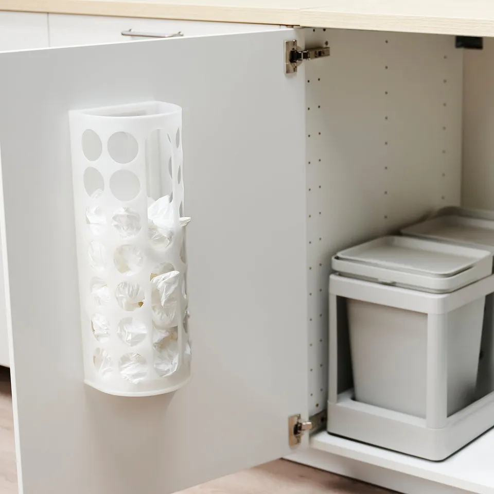 White VARIERA bag dispenser on cabinet door for organising plastic bags.
