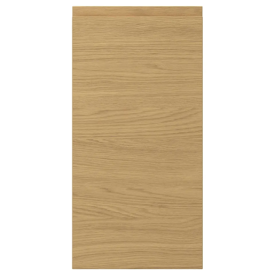 A rectangular VOXTORP door front in an oak finish with integrated handles, giving it a sleek and modern look.