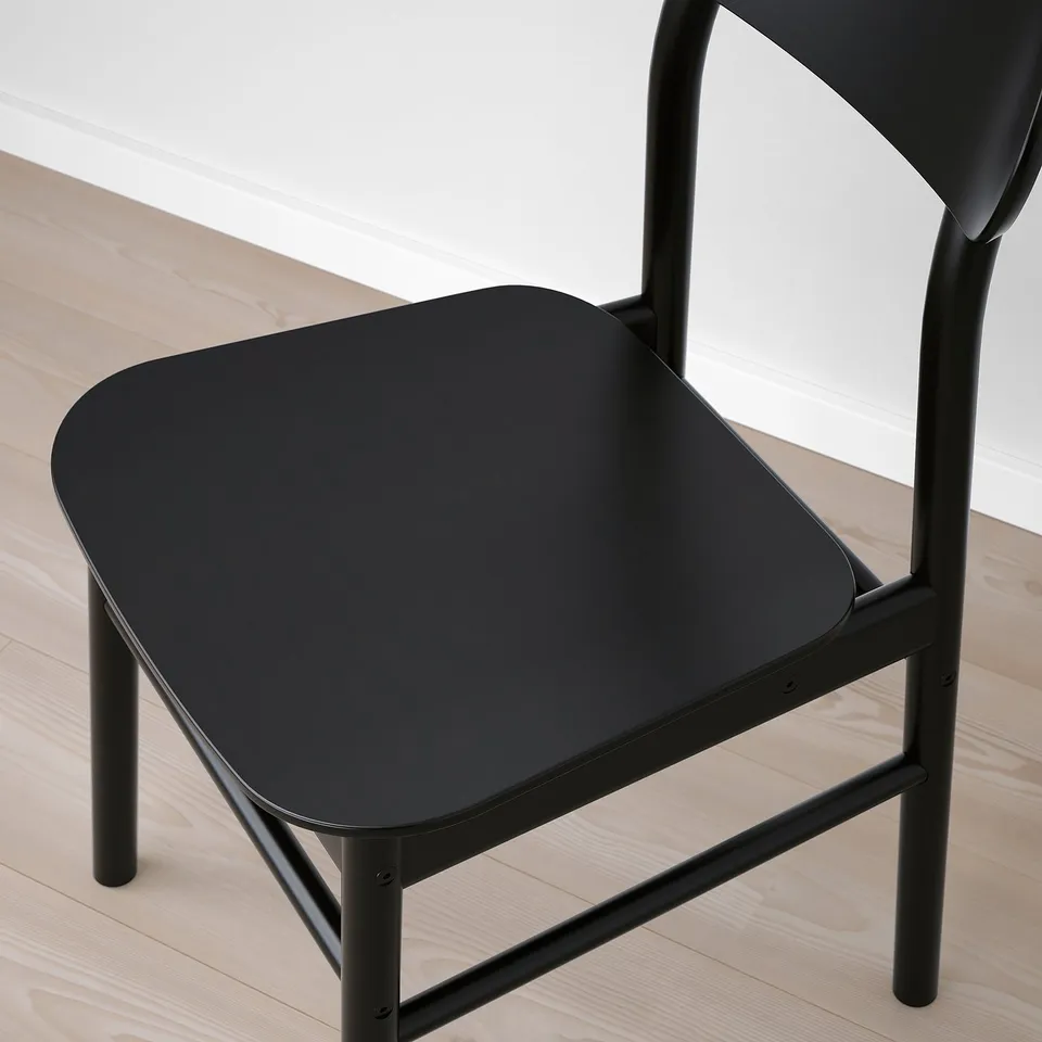Modern black chair with sleek metal frame and smooth seat; minimalist design.