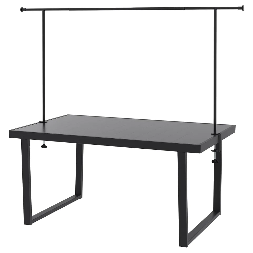 The VÄRMANSÖ outdoor table is black with a rectangular aluminium top and four steel legs. It includes a middle rail and decorative rod.