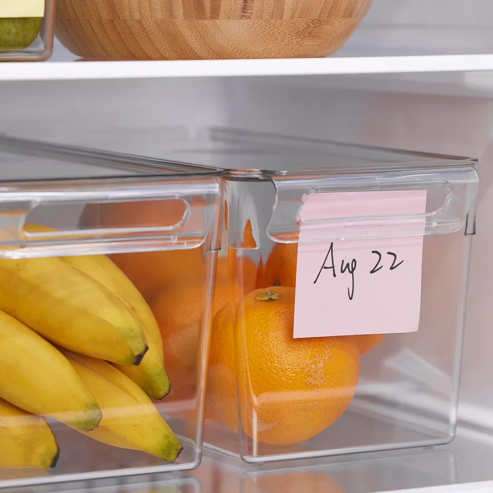 Clear fridge storage box with lid organises fruits, stackable; date label under handle.