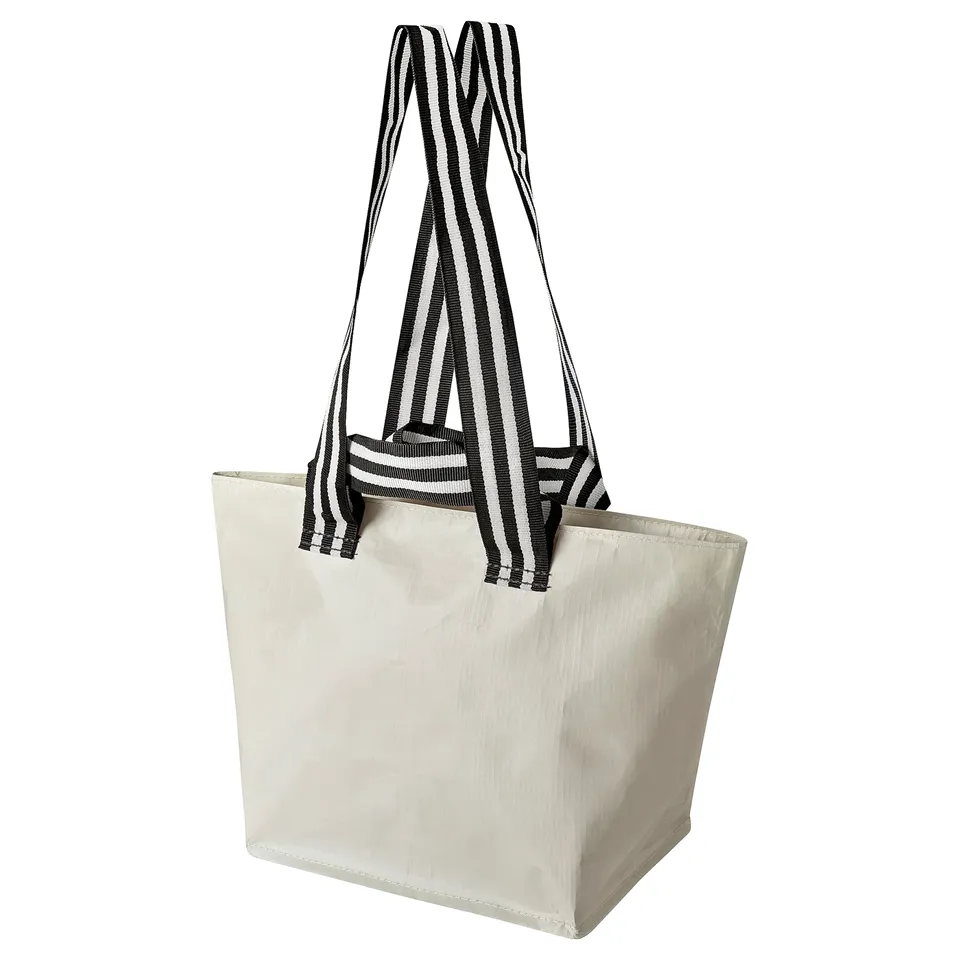 A beige GÖRSNYGG shopping bag with black and white striped handles. The bag is rectangular with sturdy handles for carrying.