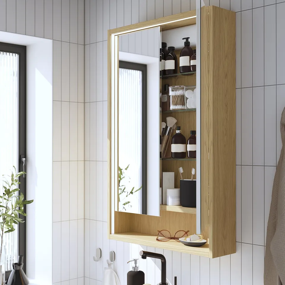 Mirror cabinet with integrated lighting organises toiletries neatly, enhancing bathroom functionality and safety.