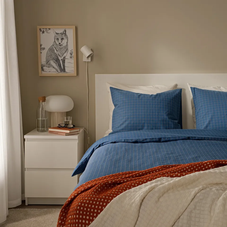 Bedroom with DOFTAKLEJA blue check/stripe duvet, fox art, bedside table with lamp.