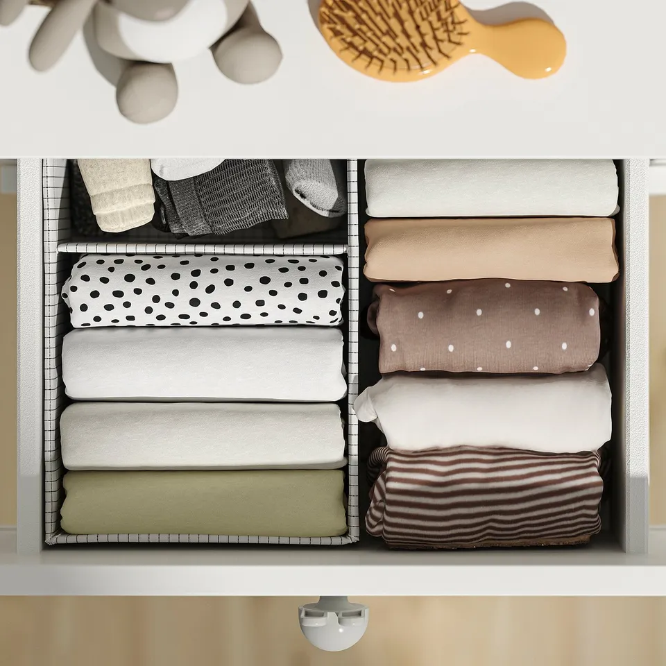 Drawer organiser with multiple compartments, neatly folding clothes. Automatic drawer closing mechanism.
