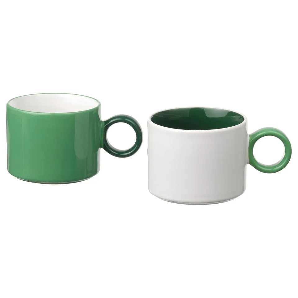 Two green and white mugs with contrasting colour schemes, featuring simple, functional design and stoneware material.