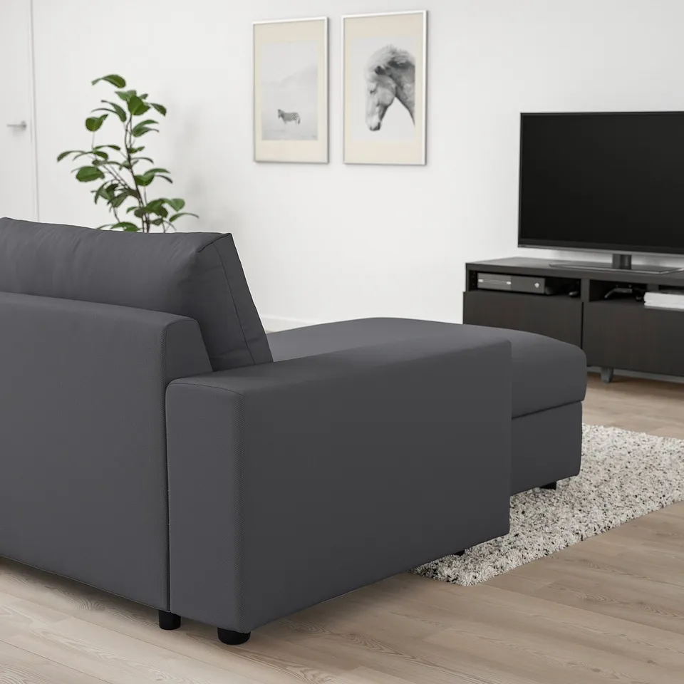 Modern living room with VIMLE sectional sofa in dark grey. Accompanied by tv stand and plant. Sofa appears large relative to room items.