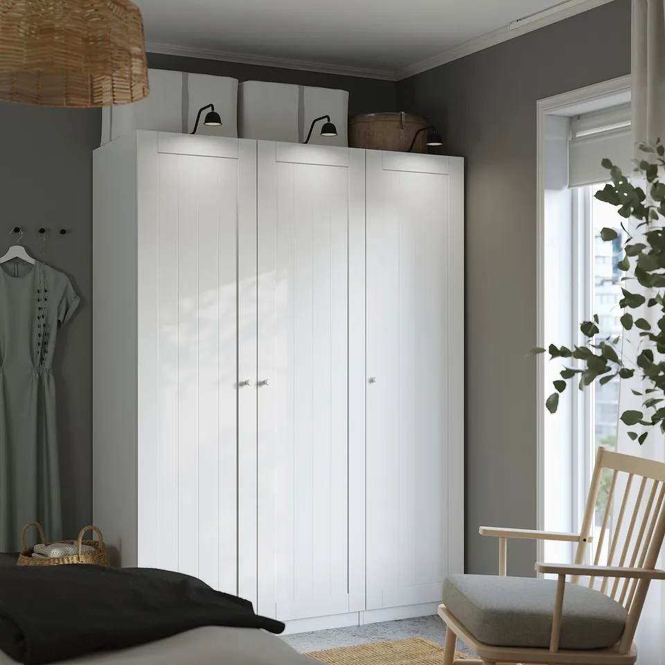 A bedroom with a tall, modern GULLABERG wardrobe, white and minimalist.