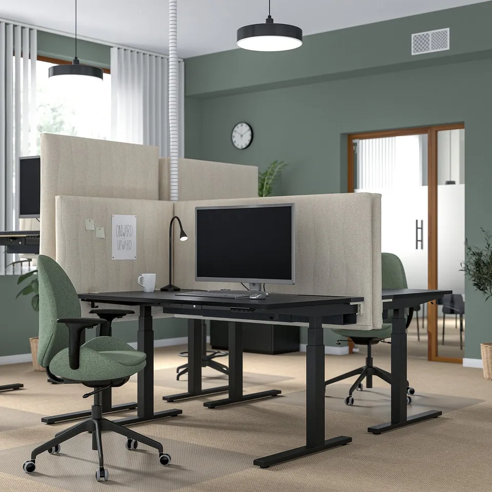 Modern sit-stand desk, MITTZON, with green chairs, beige dividers, wall clock.