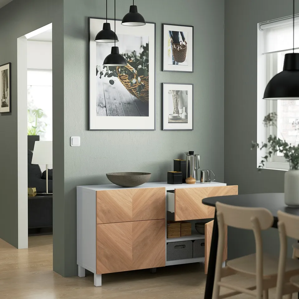 Modern kitchen with BESTÅ sideboard offering storage, featuring adjustable shelves, integrated push-open drawers, and decorative art.