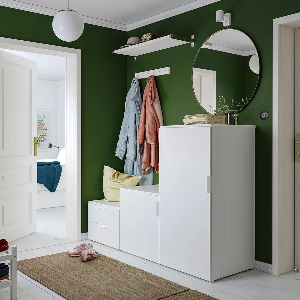 Modern entryway with green walls, featuring IKEA PLATSA storage units, shelves, drawers, coat rack, and mirror.