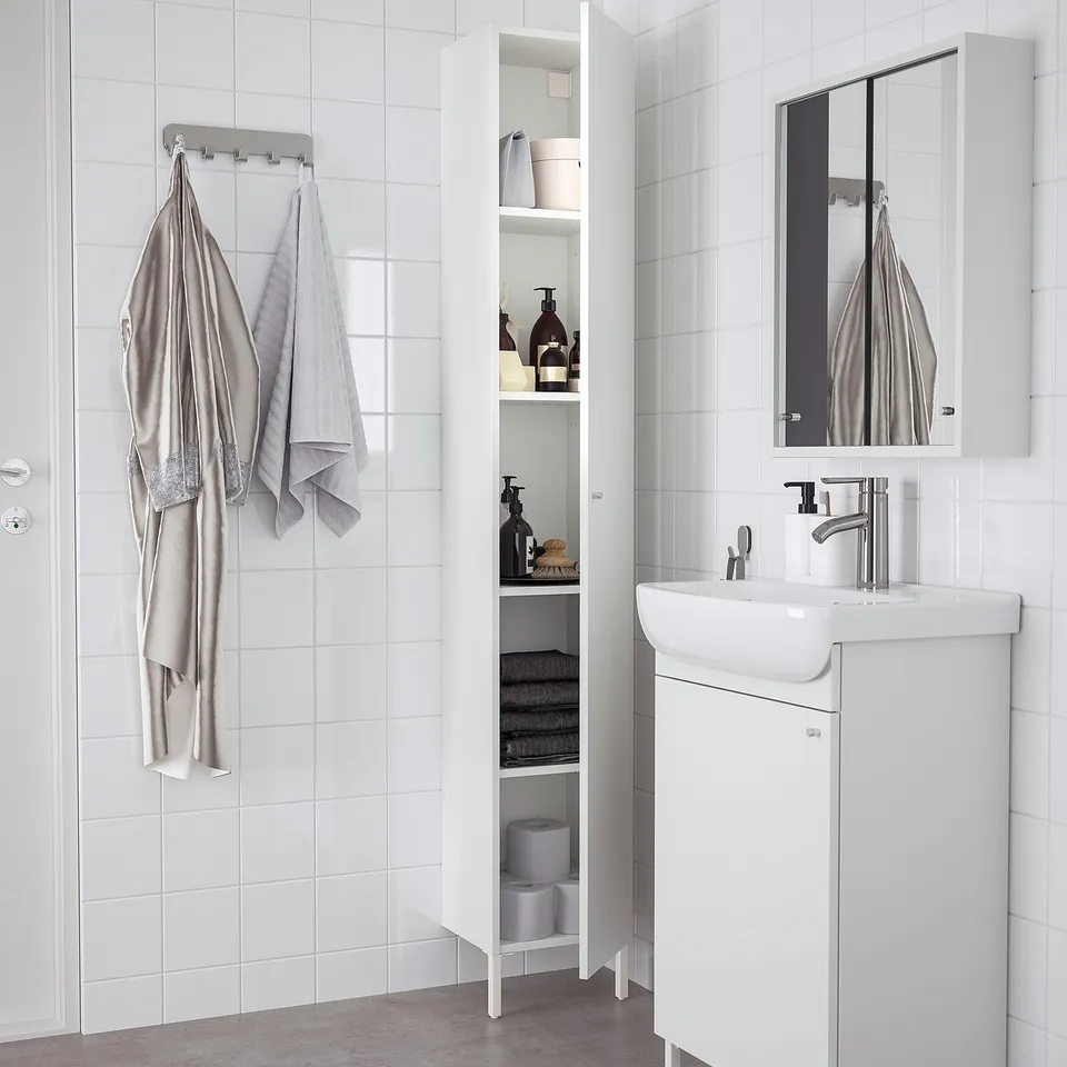 White NYSJÖN cabinet in bathroom with ample storage for toiletries and towels, left/right door option.