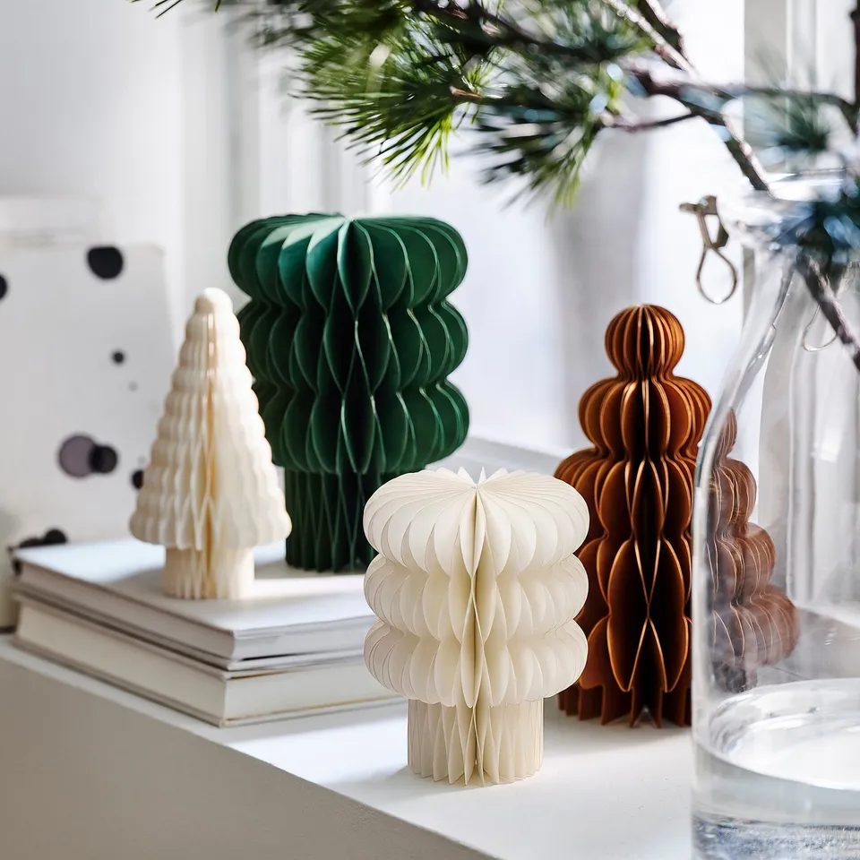 Mini paper christmas trees in green, white, and brown; decorated shelf.